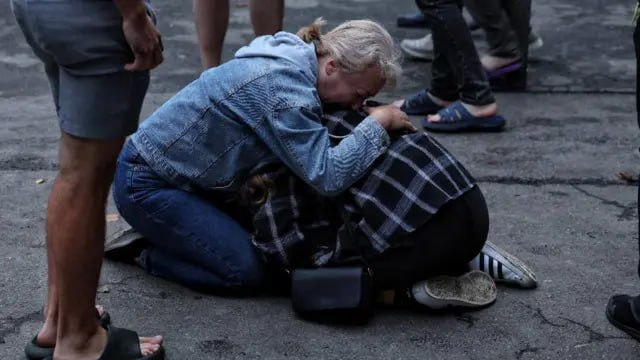Жінка втішає постраждалу після обстрілу
